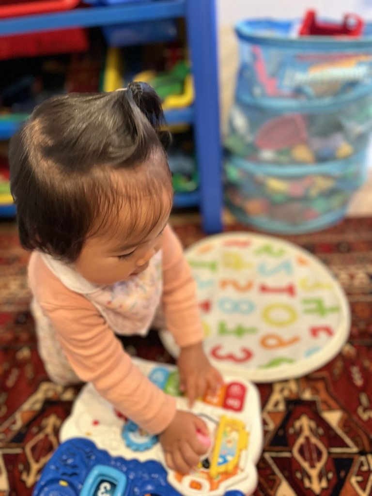 Adorable infant baby playing with educational toys