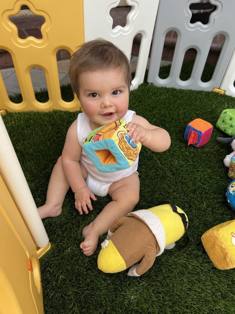 cute baby is playing with toy blocks.