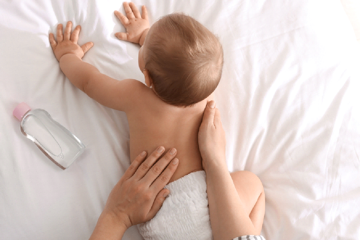 A woman massaging her baby.