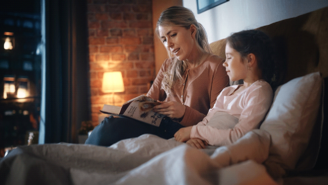 A mother reading a story to her small daughter.