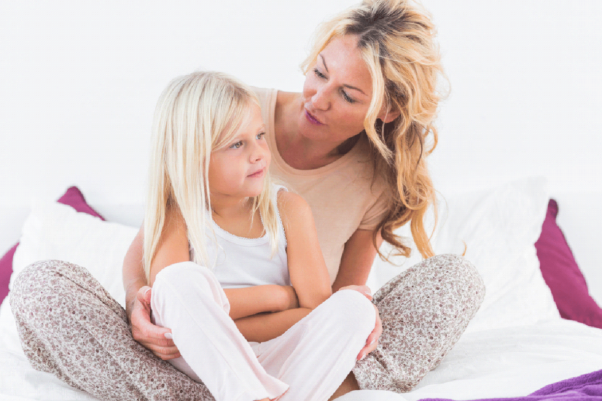 Mother talking to her daughter in the bedroom.