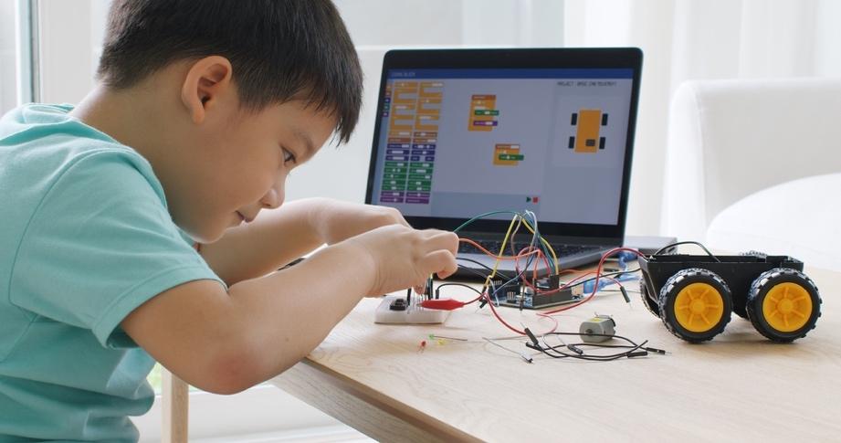 Asia home school young small kid happy smile self-study online lesson excited make AI circuit toy. STEM STEAM digital scratch class on laptop screen for active children play arduino enjoy fun hobby.
