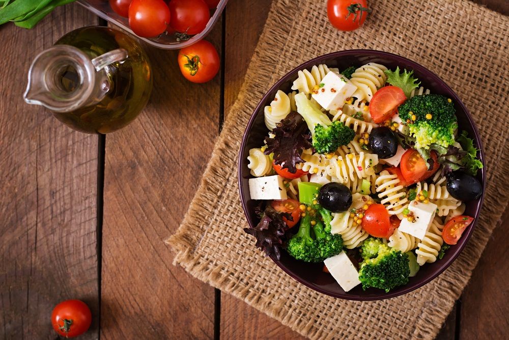 Pasta salad with tomato, broccoli, black olives, and cheese feta.