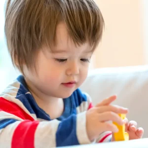 Toddler development program in Irvine with children building colorful blocks during supervised play-based learning
