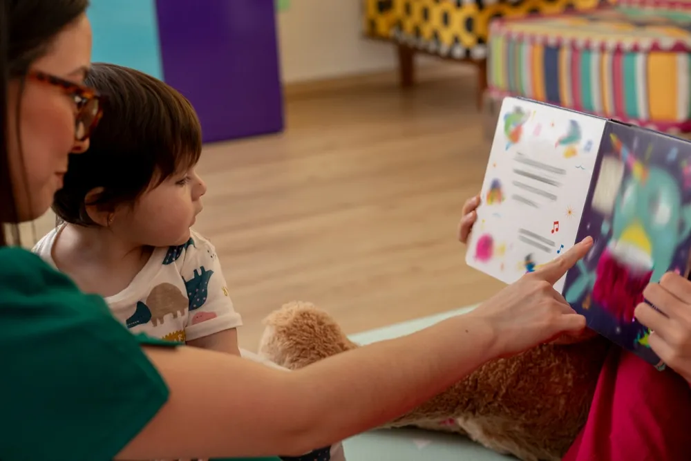Toddler Development Program in Irvine: A Complete Guide for Parents 2 DeeCyDa Caterpillar Program caregiver reading an interactive story to toddlers in a nurturing Irvine daycare environment